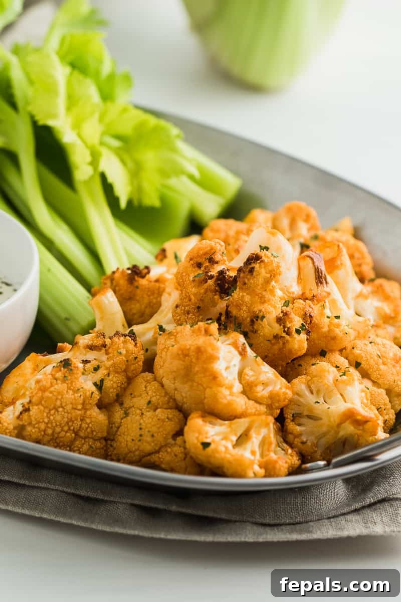 Healthy Buffalo Cauliflower Bites Close-up of cooked buffalo cauliflower wings on a plate, showing the rich coating and slight char, ready to be served.