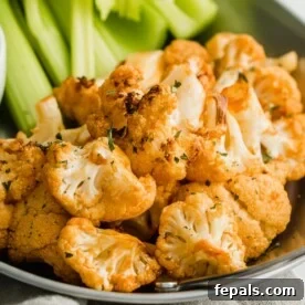 Buffalo Cauliflower Poppers 3 Buffalo cauliflower wings on plate with celery.