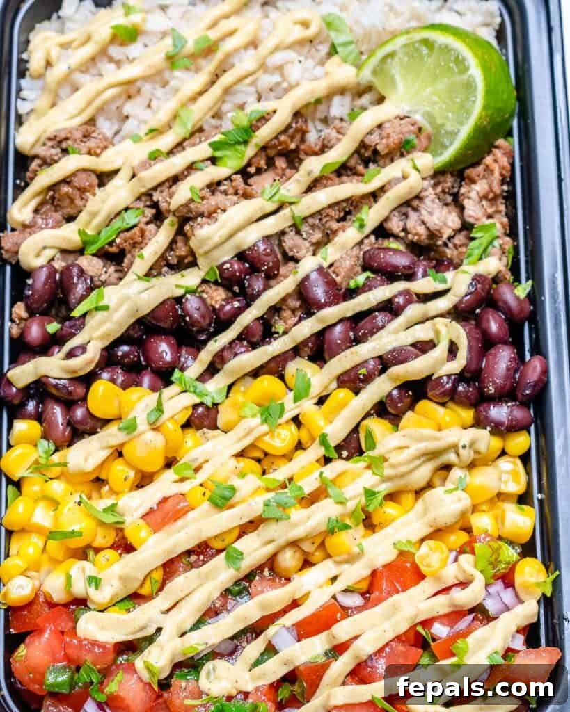 Beef Burrito Power Bowls 3 close up side shot of a beef burrito bowl with an avocado cream sauce drizzled over it