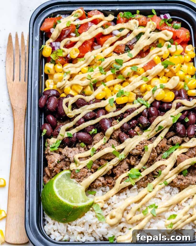 Beef Burrito Power Bowls 8 side shot of a black meal prep container with beef burrito and rice with beans and corn