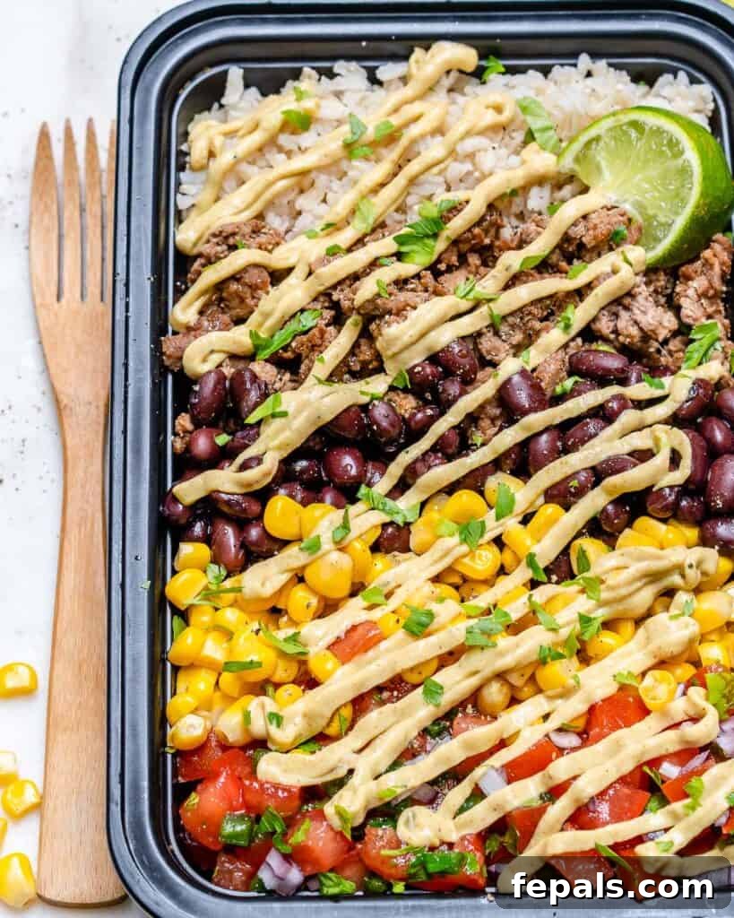 Beef Burrito Power Bowls 9 a meal prep bowl that has beef burrito with rice corn and beans, and a drizzle of avocado cream sauce