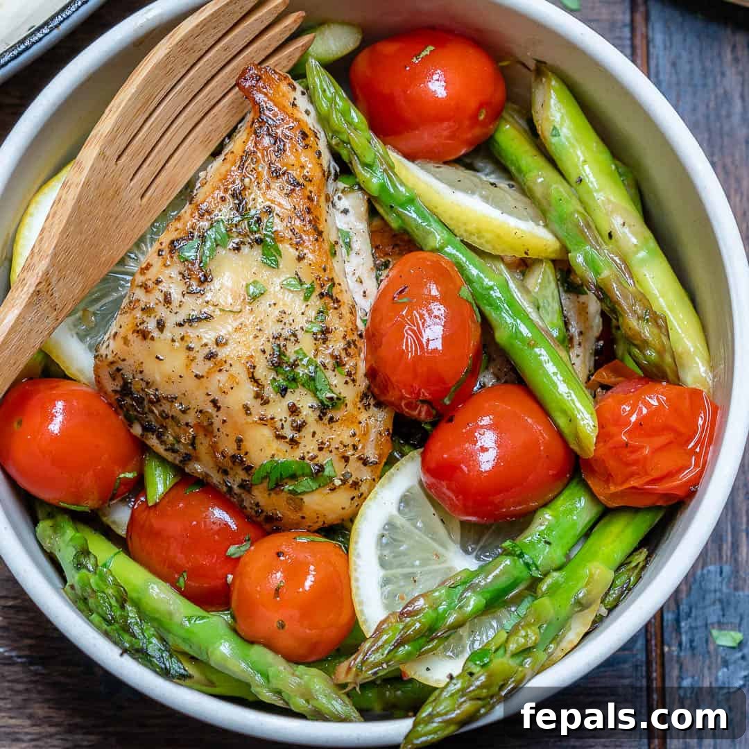 Seared Garlic Chicken Perfection 6 A bowl of cooked chicken breast with asparagus and cherry tomatoes, perfectly portioned and ready to eat.