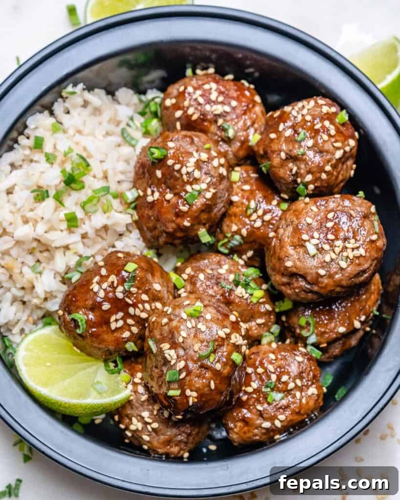 Honey Sriracha Glazed Asian Meatballs 2 top view of a black meal prep bowl with Honey Sriracha meatballs and rice