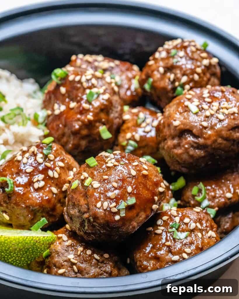 Honey Sriracha Glazed Asian Meatballs 5 close up of Honey Sriracha meatballs in a bowl with rice