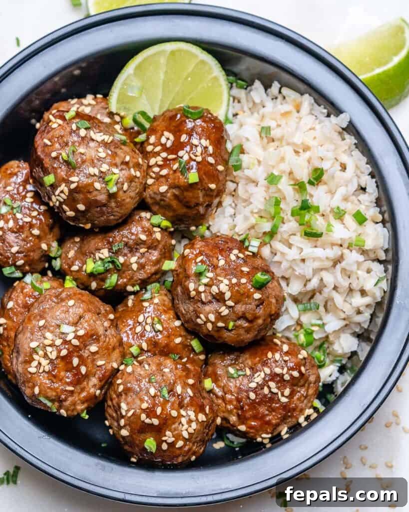 Honey Sriracha Glazed Asian Meatballs 6 top view of honey sriracha meatballs in a black bowl with rice