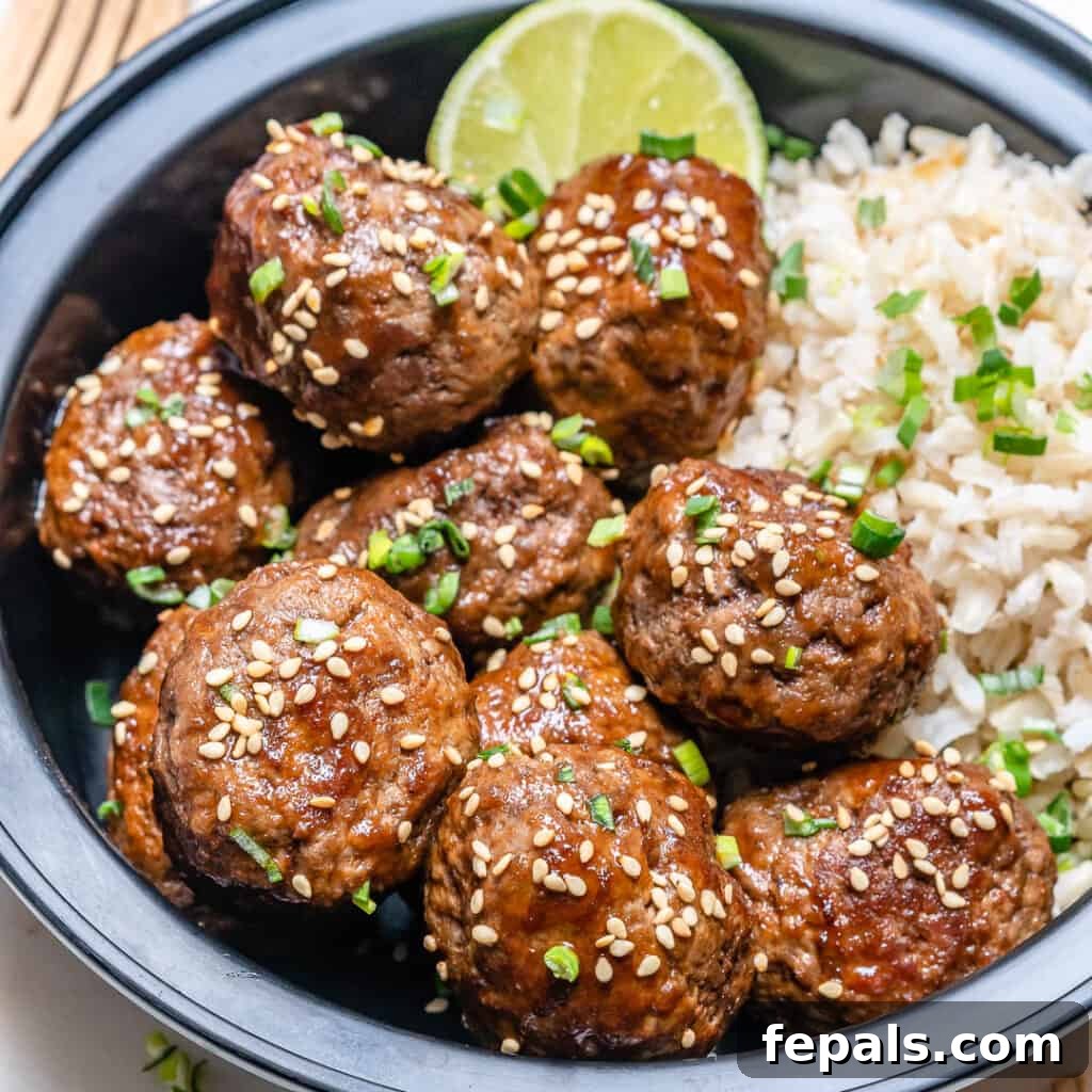 Honey Sriracha Glazed Asian Meatballs 7 side shot of Honey Sriracha meatballs topped with sesame seeds with a side of rice in a bowl