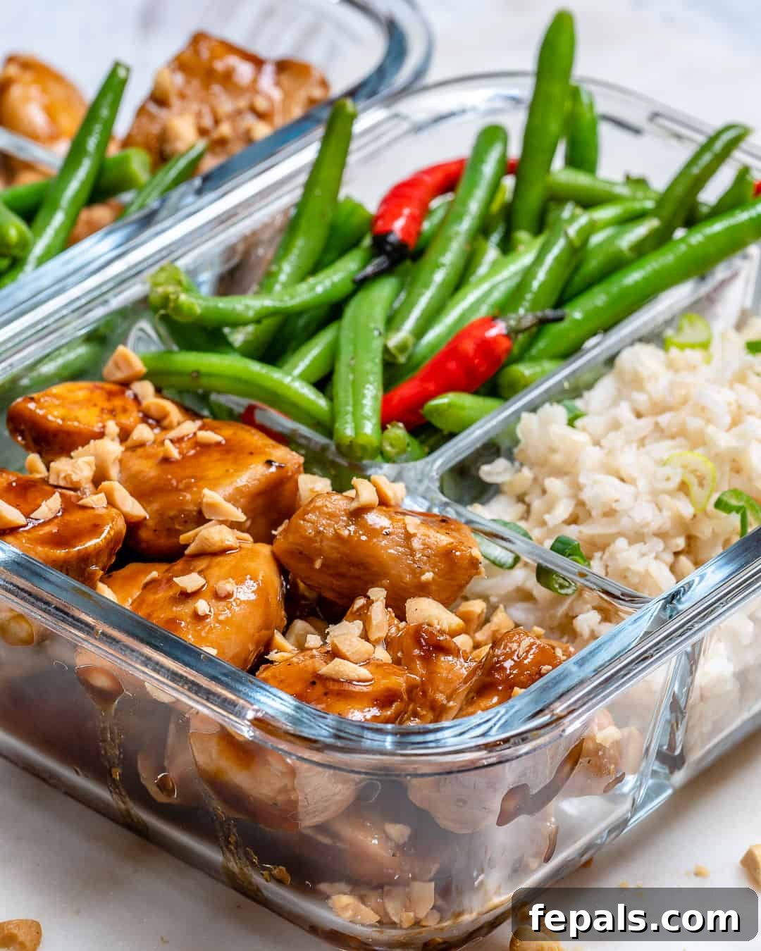 Side shot of Sweet and Spicy Chicken in a glass meal prep container, showcasing its presentation.