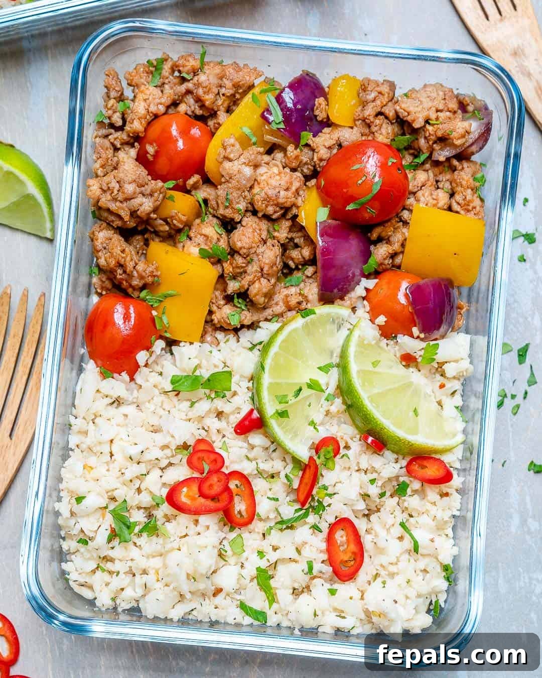 Ground Turkey and Cauliflower Rice Skillet Ground turkey and cauliflower rice recipe in a glass container with fresh veggies, highlighting a wholesome and colorful meal.