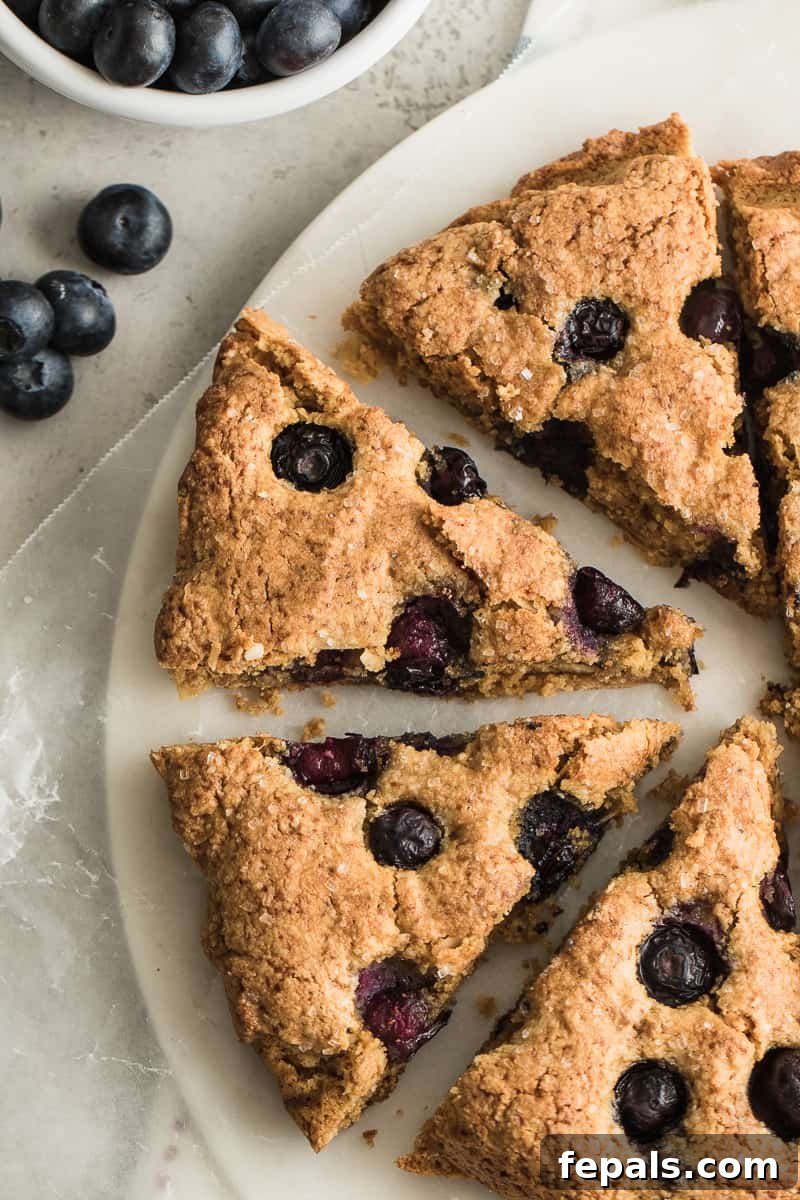 Berry Bliss Gluten-Free Scones 2 Freshly baked gluten-free blueberry scones on a plate, ready to be enjoyed.