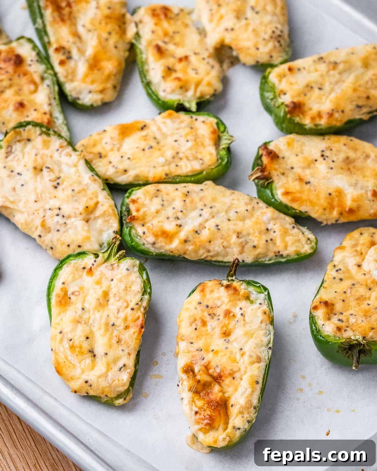 A plate brimming with freshly baked jalapeno poppers, golden and bubbly, garnished with fresh herbs, showcasing their irresistible appeal.