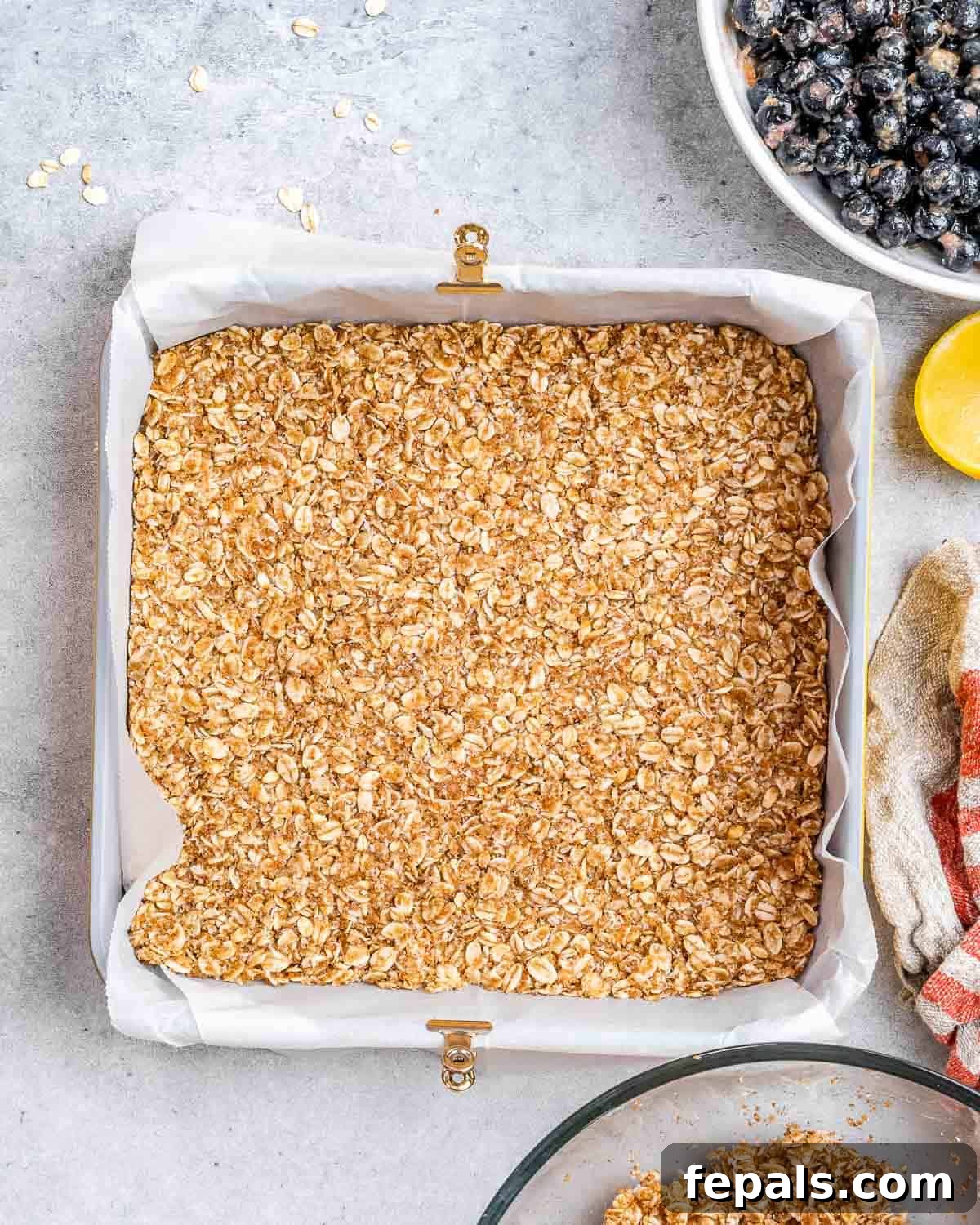 oatmeal mixture added into a pan and pressed down as a base. 