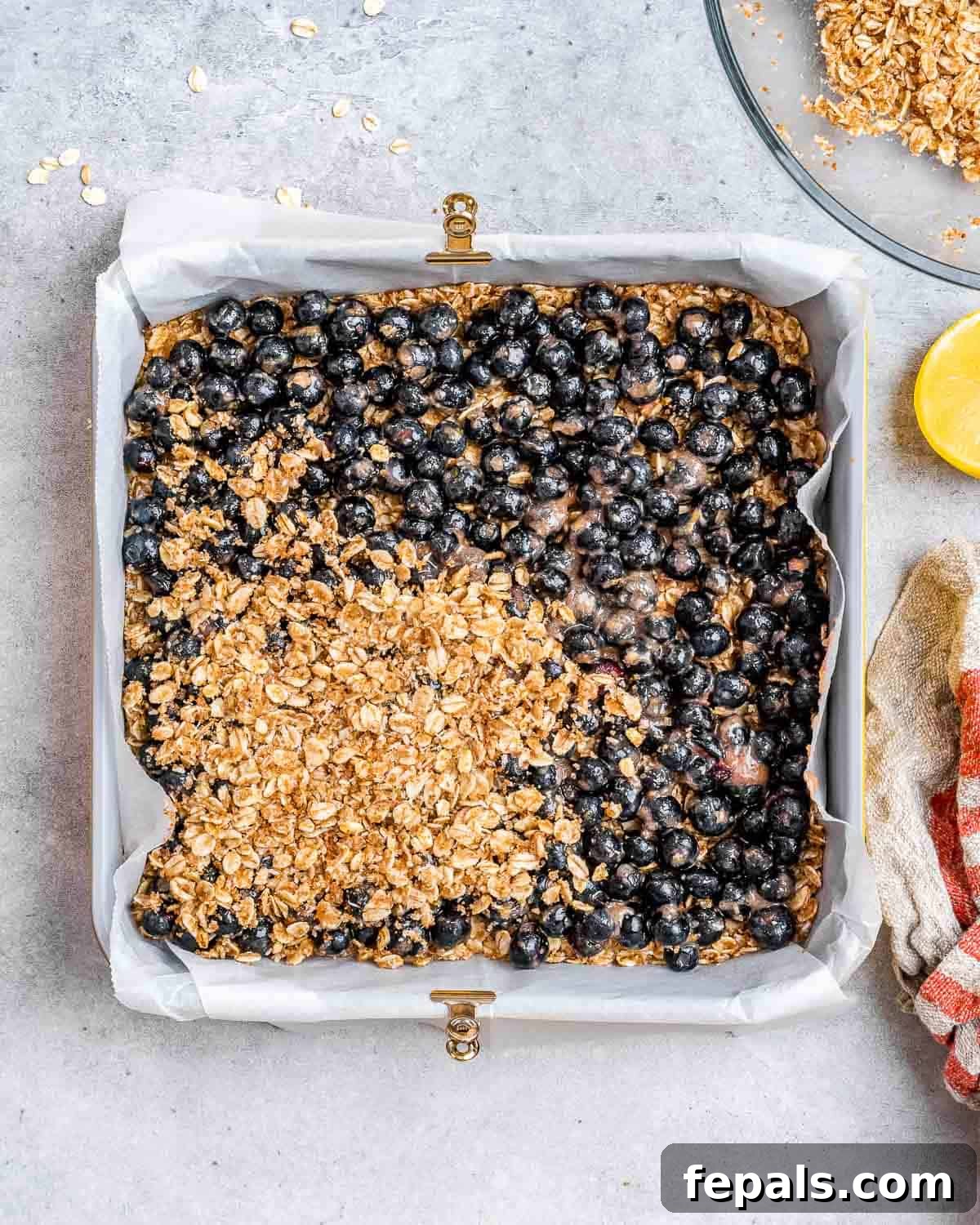 blueberry mix is added over the oatmeal base. oatmeal topping added over the fresh blueberries.