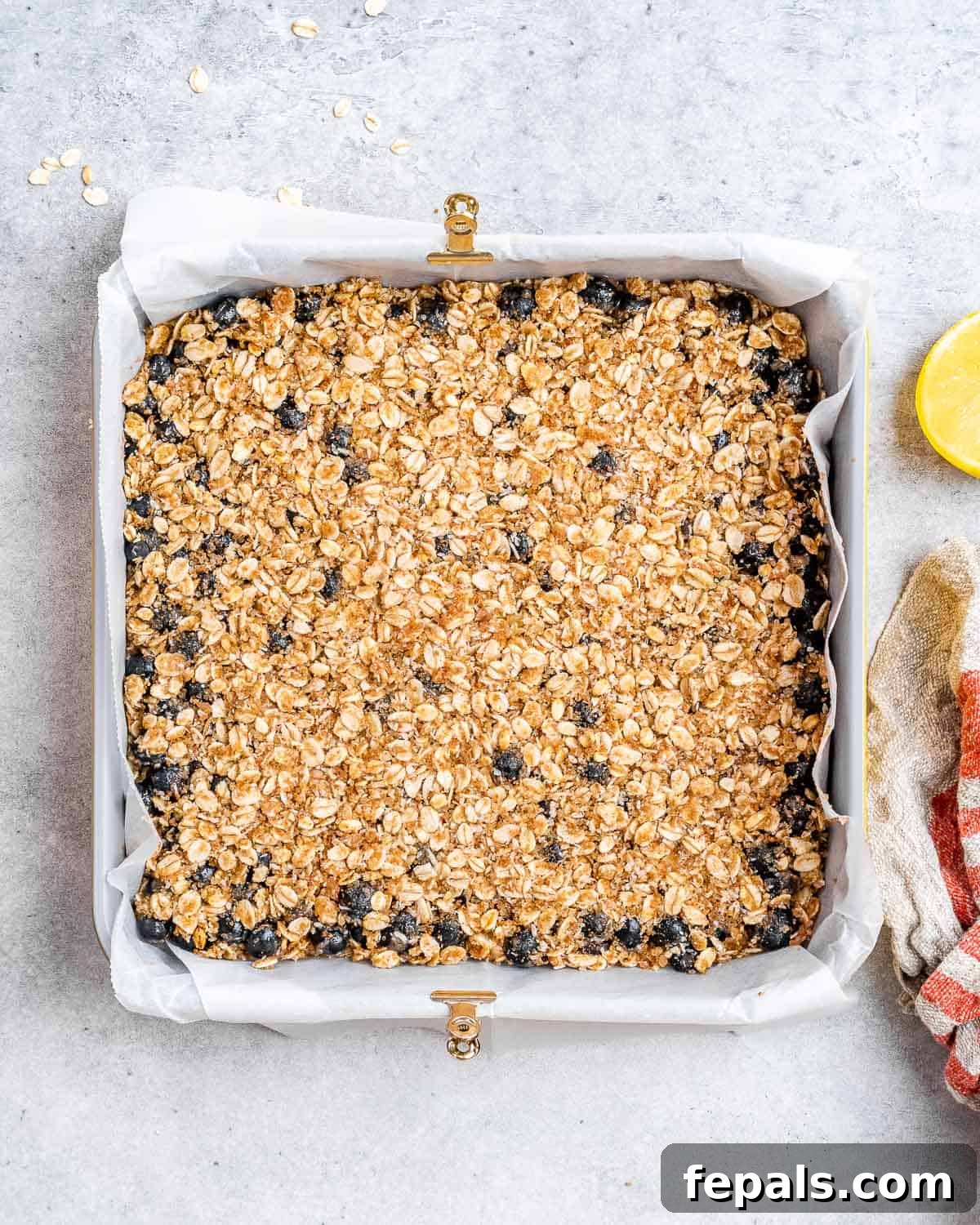 oatmeal topping added over blueberry mixture to make oatmeal bars before baking.