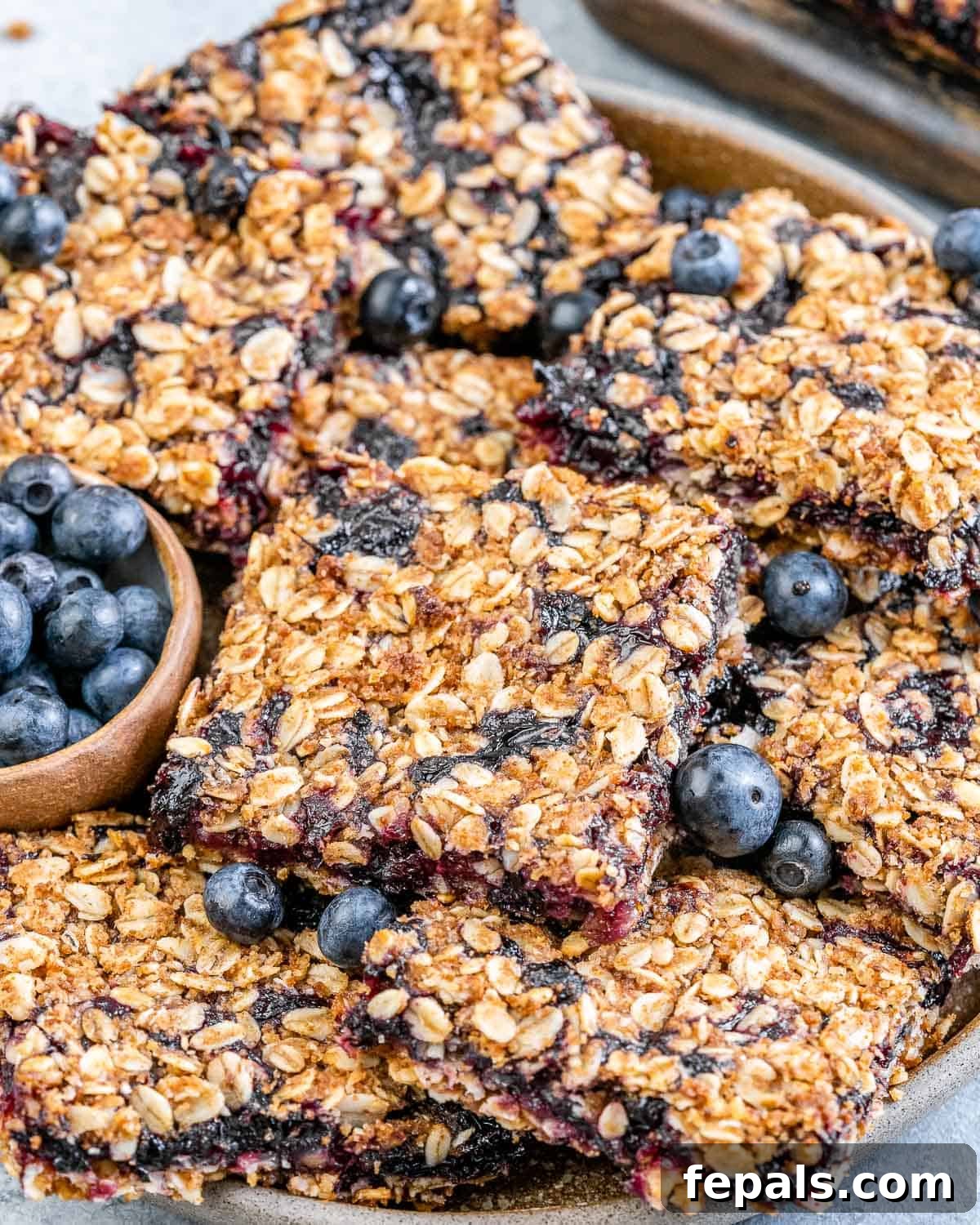 oatmeal bars with blueberries added to a plate.