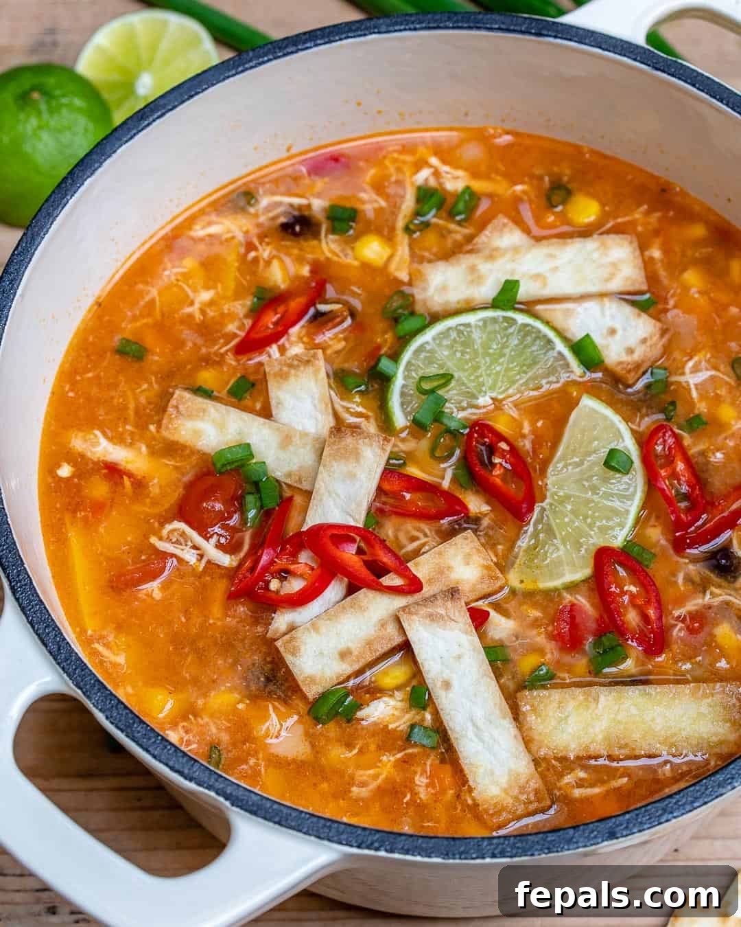 The best chicken soup recipe, served in a rustic bowl with lime wedges
