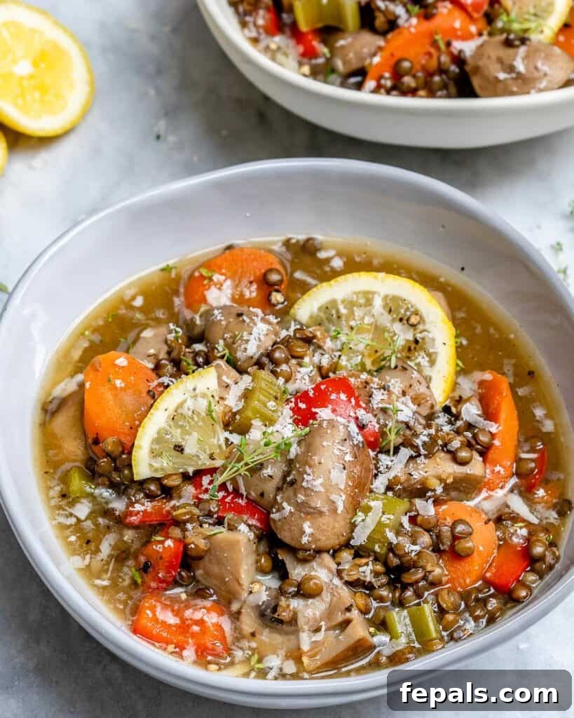 side shot of a bowl of lentil and mushroom soup with carrots 
