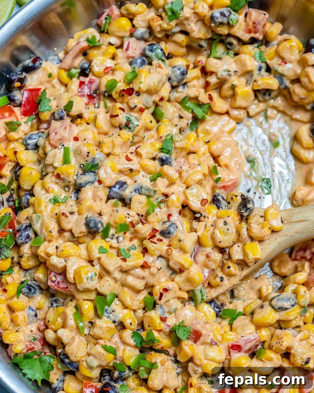 Creamy Corn Salad Recipe that's a perfect side dish Close-up of creamy corn salad with black beans, red bell pepper, and cilantro, perfect as a side dish.