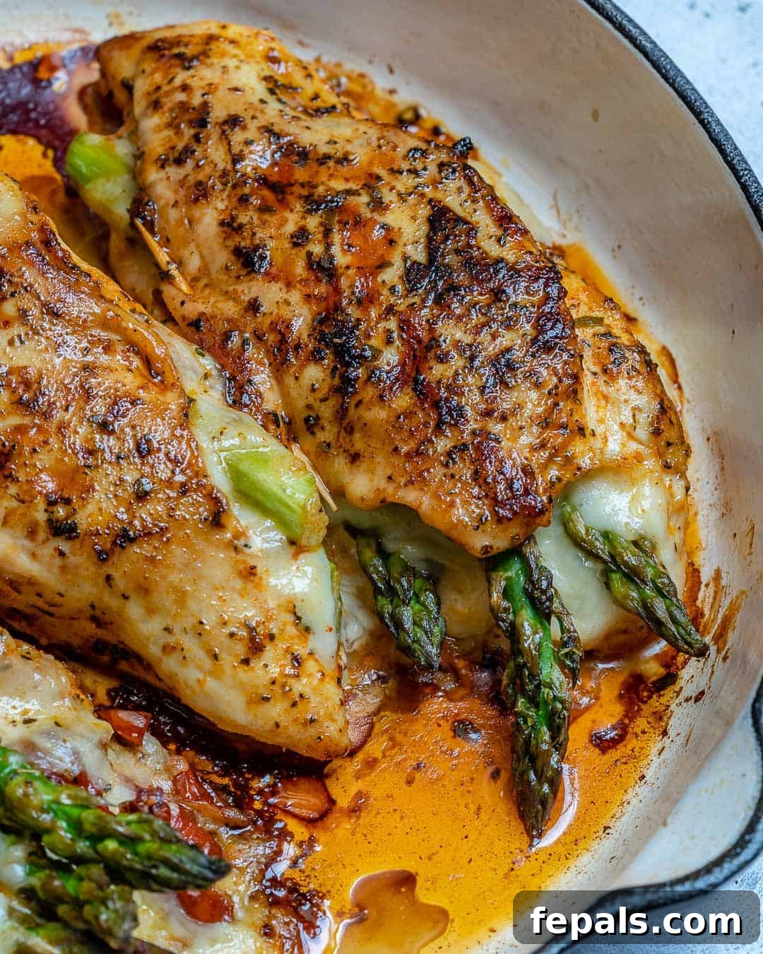 chicken stuffed with cheese and veggies on a skillet