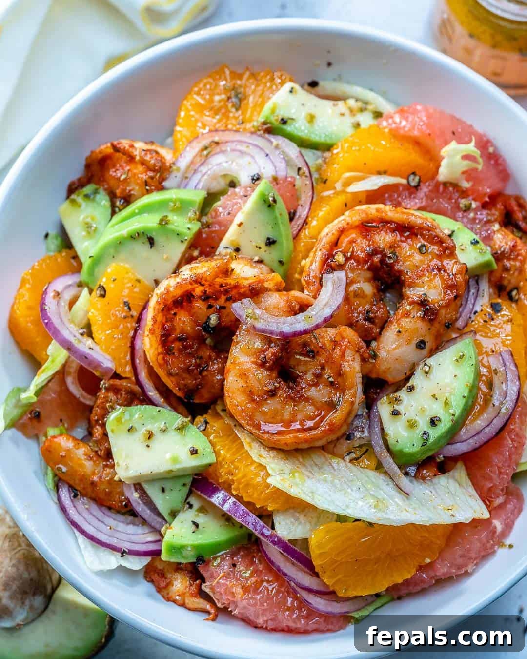 A beautifully presented shrimp salad in a white bowl, ready to be served.