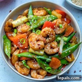 Szechuan shrimp stir fry with veggies in a bowl.