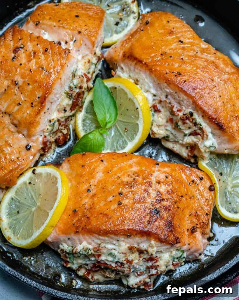 side shot of stuffed salmon on a skillet with lemon slices to garnish