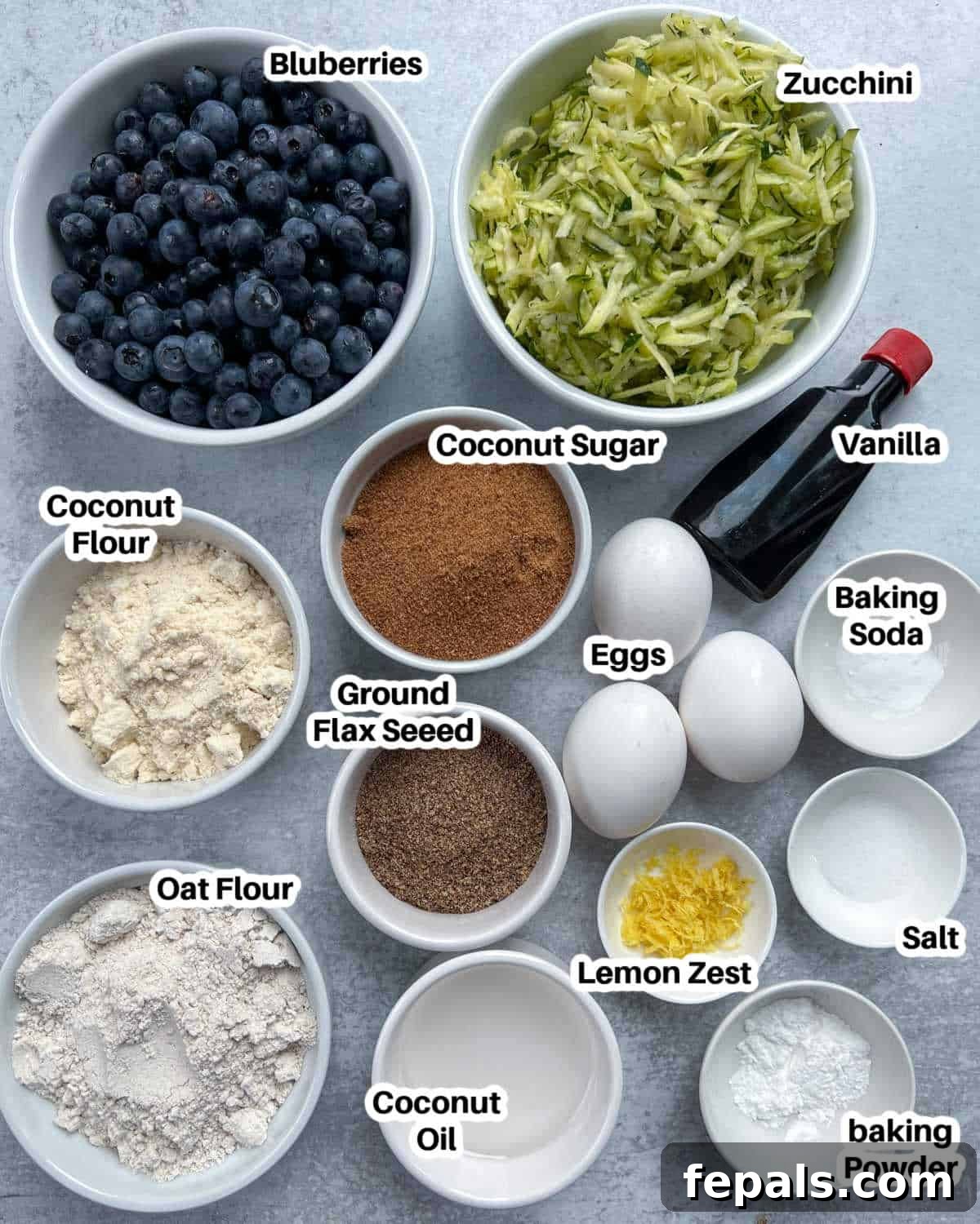 Delicious Blueberry Zucchini Bread 3 A curated display of fresh ingredients laid out, including eggs, zucchini, blueberries, and various flours, ready for baking blueberry zucchini bread.