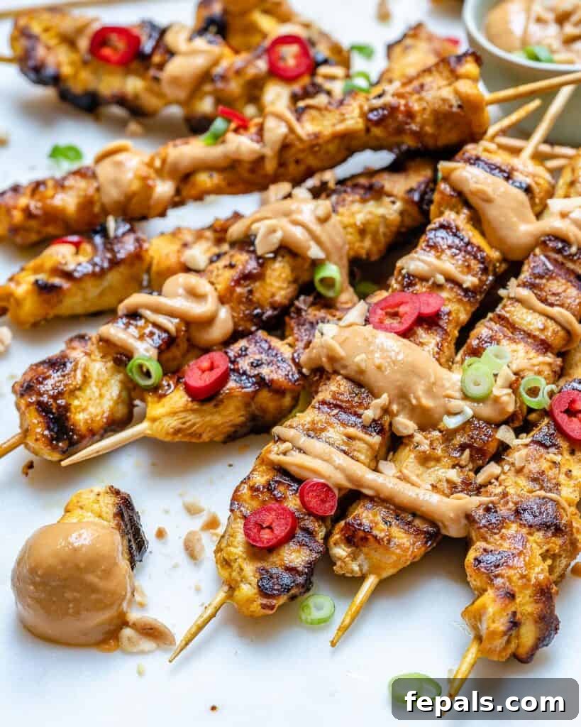 side shot of chicken satay skewers with peanut sauce
