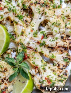 Chargrilled Cauliflower Steaks with Fresh Chimichurri 16 grilled cauliflower steaks on a pan topped with chimichurri sauce.
