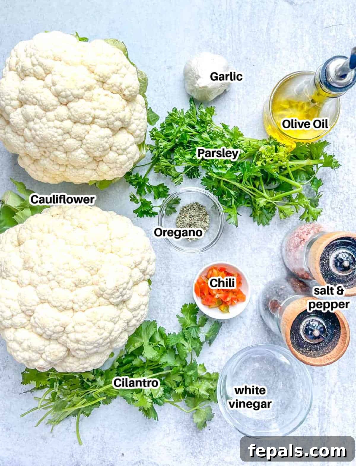 Chargrilled Cauliflower Steaks with Fresh Chimichurri 4 A flat lay photograph displaying all the fresh ingredients needed for making cauliflower steaks and chimichurri sauce.