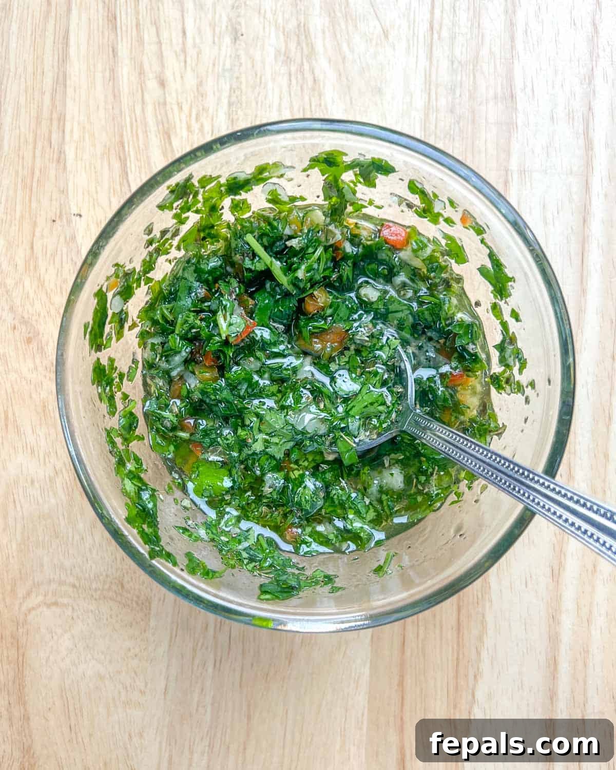 Chargrilled Cauliflower Steaks with Fresh Chimichurri 5 Freshly prepared chimichurri sauce mixed in a medium bowl, ready to infuse flavor.