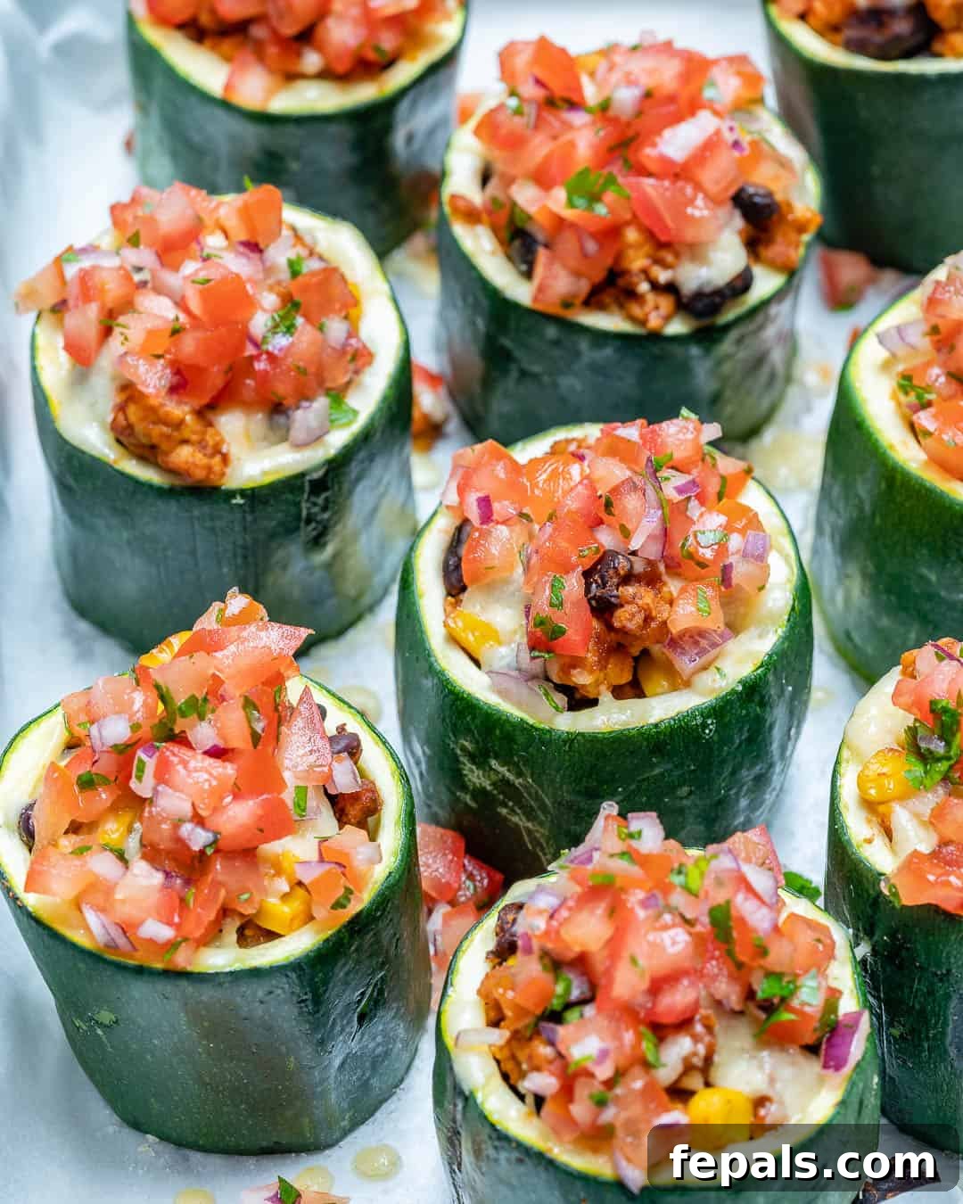 Loaded Zucchini Tacos 2 Small zucchini cups generously stuffed with a savory meat mixture, topped with fresh chopped tomatoes and melted cheese.