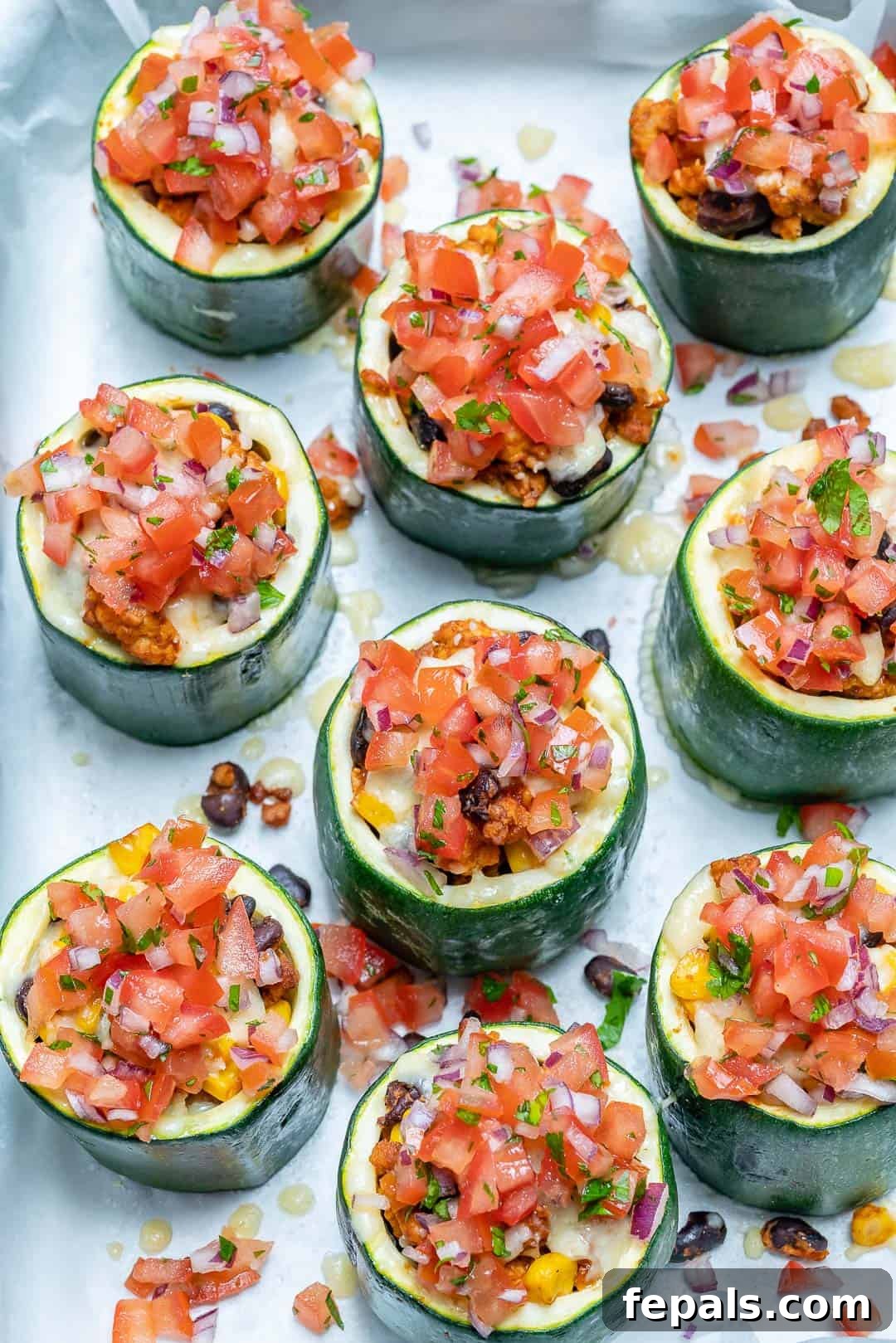 Loaded Zucchini Tacos 7 Stuffed zucchini cups generously filled with taco meat and melted cheese, lined up on a sheet pan tray after baking.
