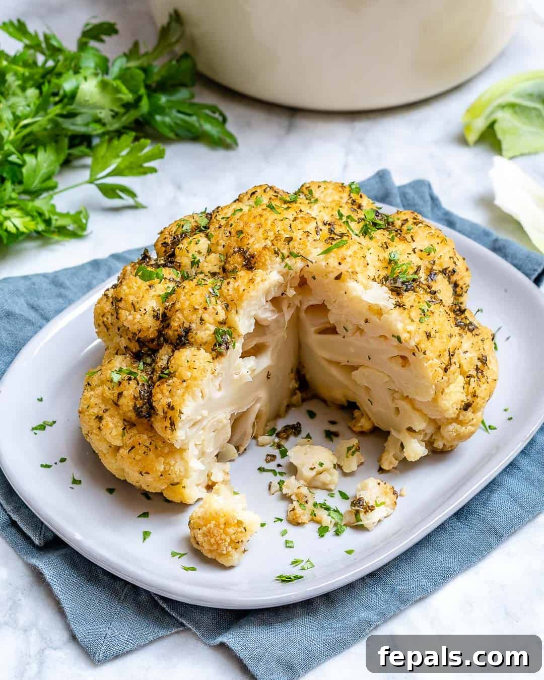 Delicious whole roasted cauliflower recipe with garlic herb sauce