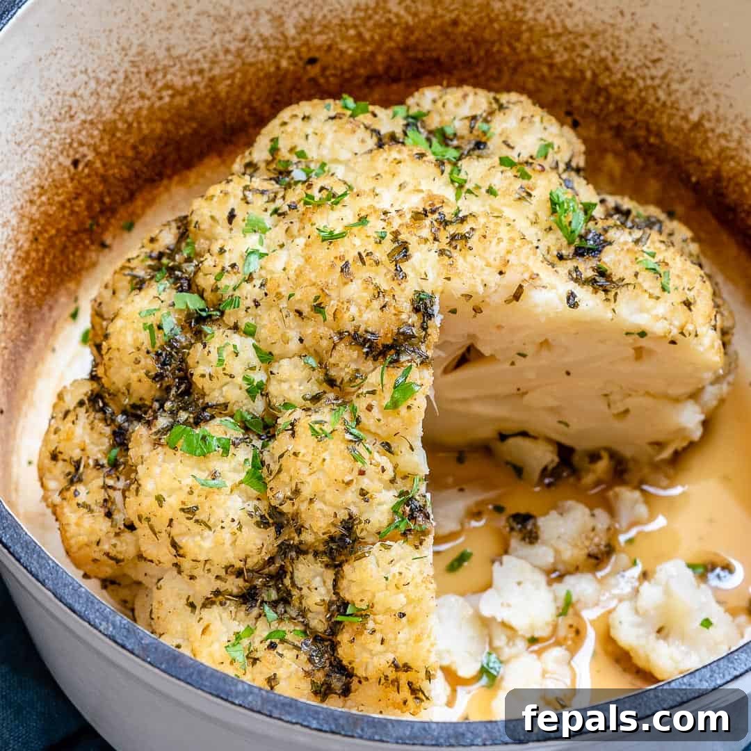 Whole roasted cauliflower as a centerpiece on a serving board