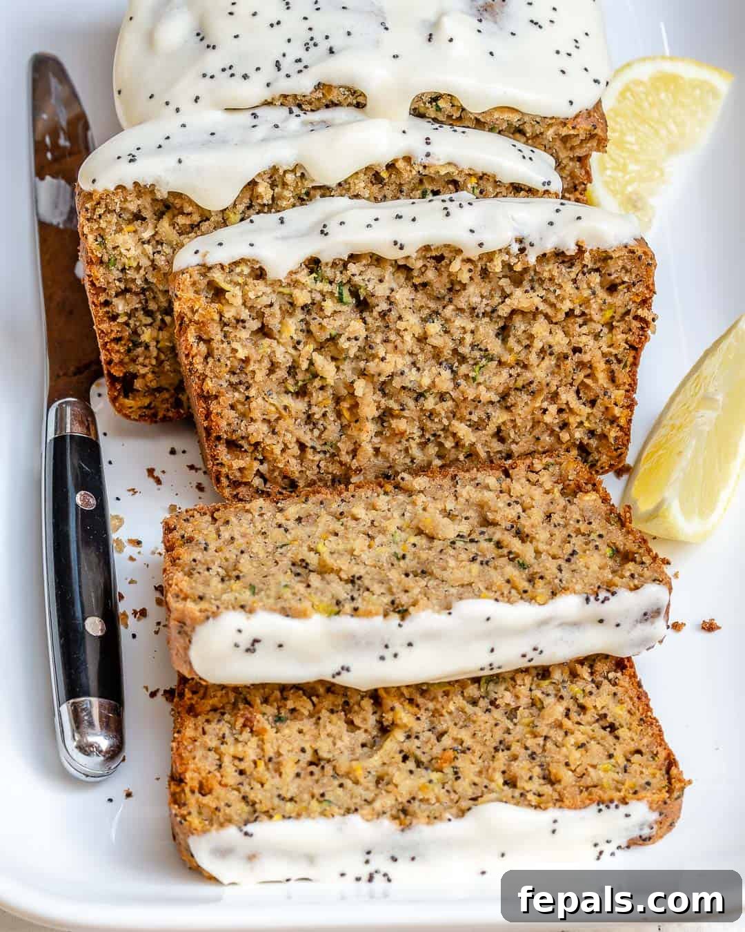 Slices of fluffy lemon poppy seed zucchini bread on a plate, drizzled with a creamy yogurt glaze.
