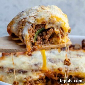 Satisfying Zucchini Lasagna Bake 14 A hearty slice of zucchini lasagna being served from the casserole dish, rich with melted cheese and visible layers.