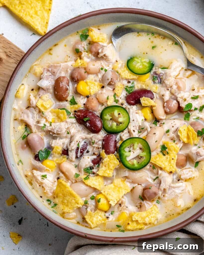 Creamy White Chicken Chili 2 top view of a bowl with white chicken chili and 3 types of beans topped with sliced jalapenos