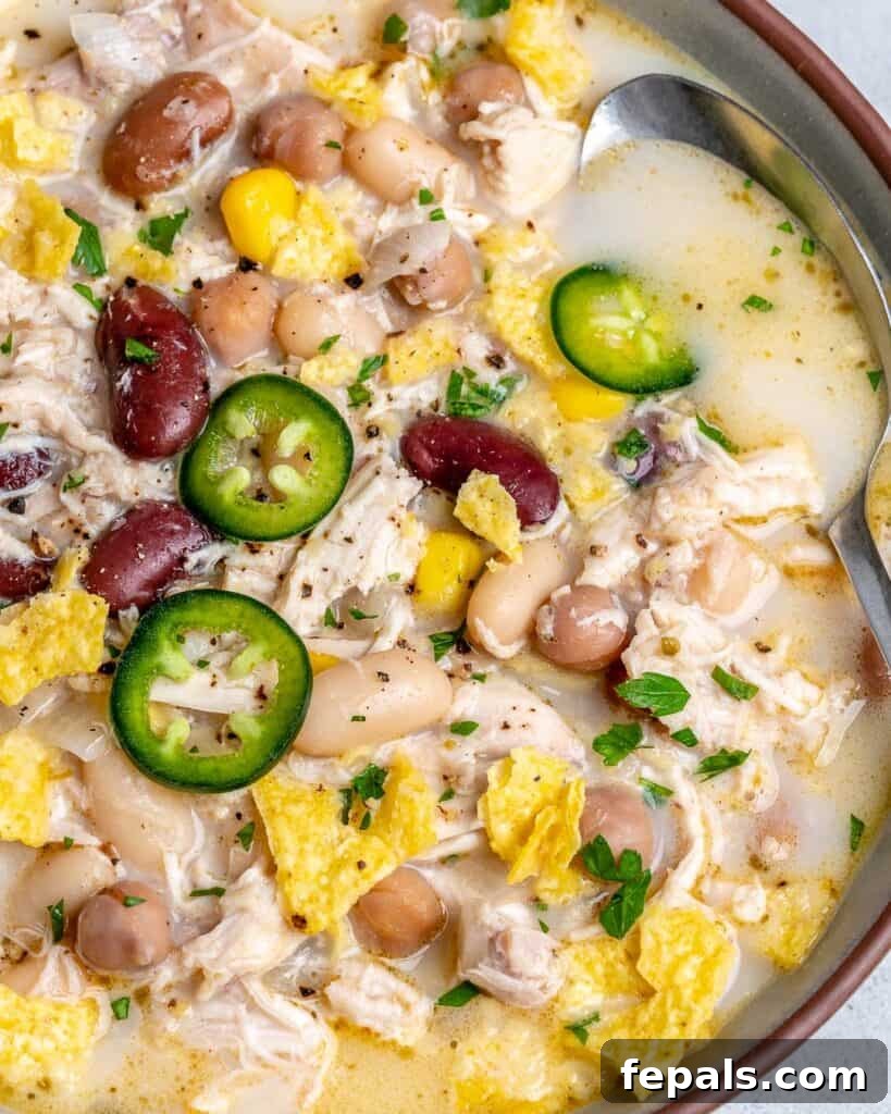 Creamy White Chicken Chili 4 close up of white chili in a bowl topped with sliced jalapenos