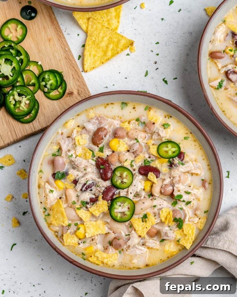 Creamy White Chicken Chili 9 bowl of white chicken chili next to a cutting board with sliced jalapenos
