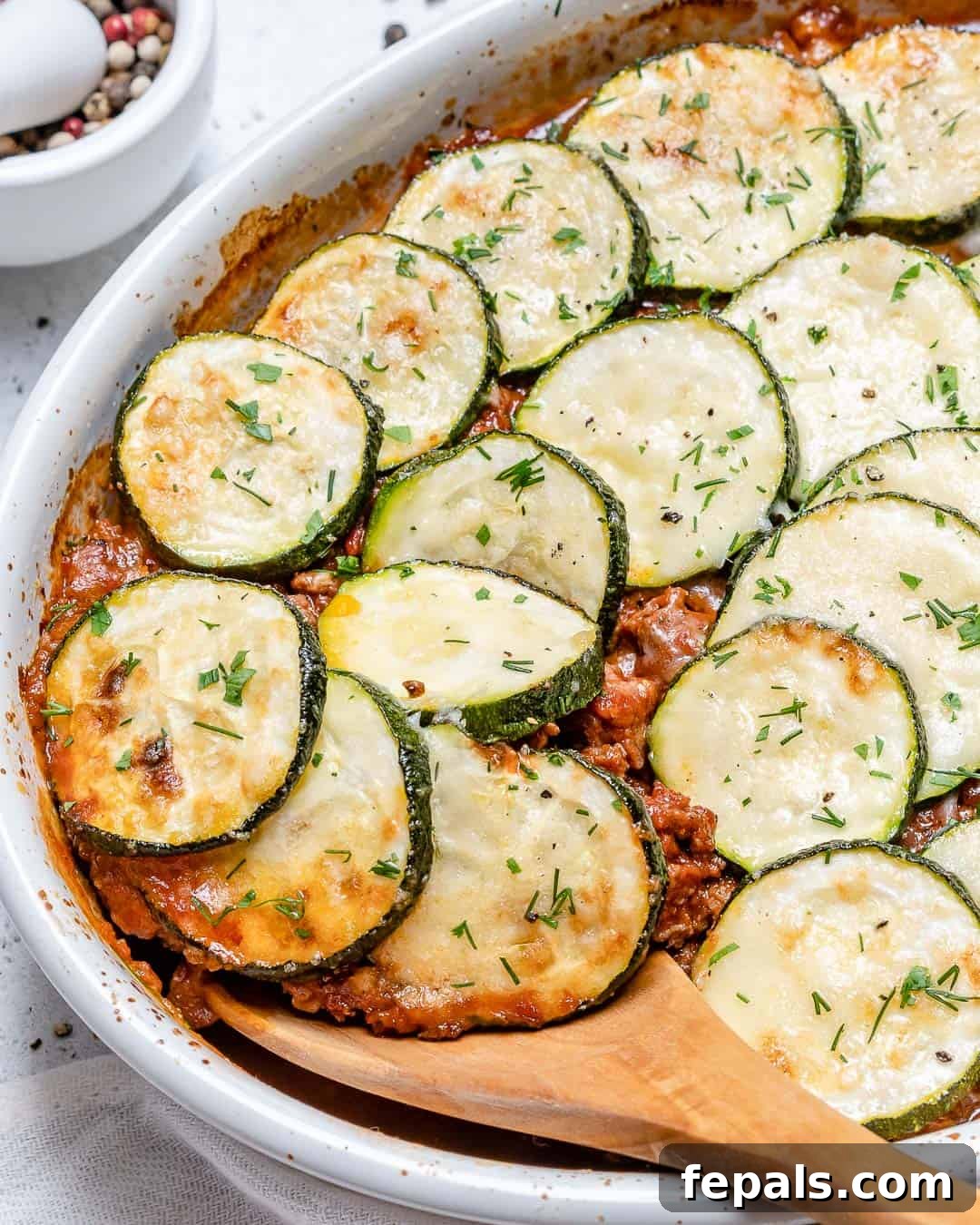 Savory Greek Zucchini Moussaka 6 A wooden spoon with a perfect portion of moussaka lifted from the baking dish, ready to be enjoyed.