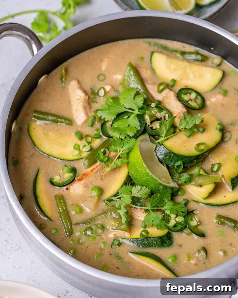 side shot of creamy chicken green curry recipe in a pan topped with fresh cilantro