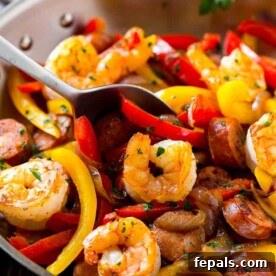 Seared Cajun shrimp, peppers, and sausage in a pan.