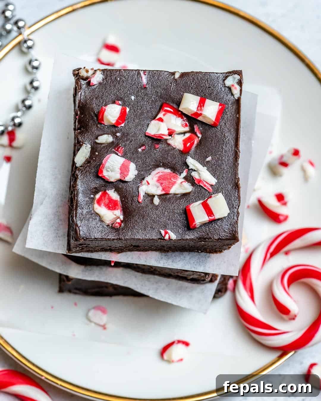 Close-up, top-down view of a single square of peppermint fudge, highlighting its texture and topping.