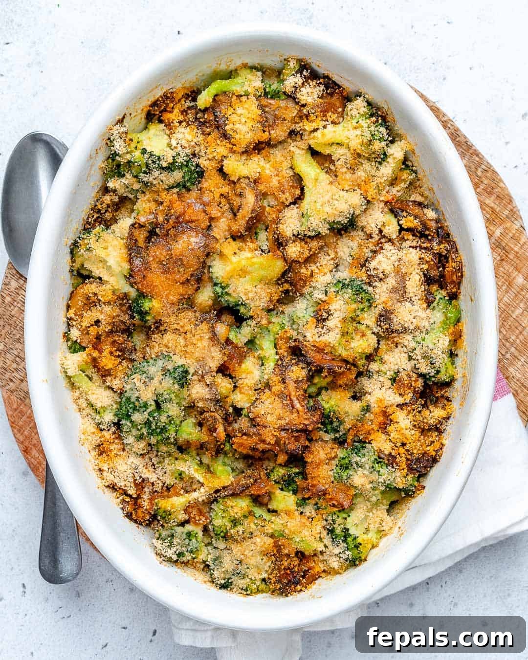 A vibrant, healthy broccoli casserole with mushrooms, no cheese, presented in an elegant white oval baking dish, ready to serve.