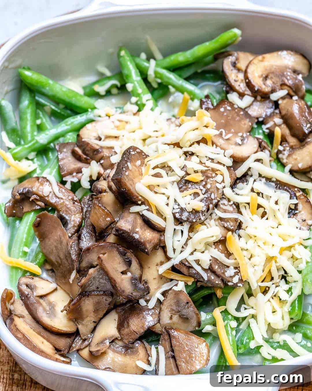 Wholesome Green Bean Delight 5 Close-up of green beans, mushrooms, and cheese ready for baking.