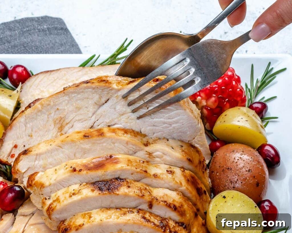 hand holding fork and spoon and grabbing a slice of cooked turkey breast from a plate