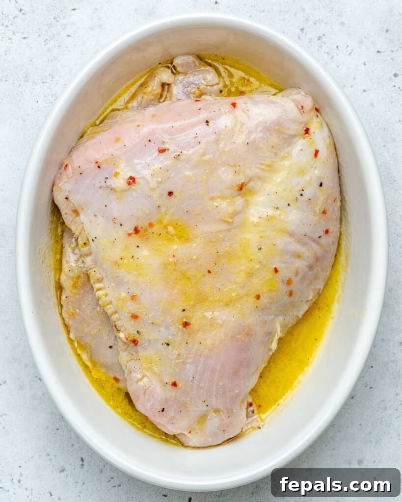 top view of marinated turkey breast in an oval white dish