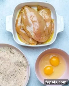 Golden Baked Chicken Cutlets 16 chicken marinated in a bowl, bread crumbs in another bowl, two eggs in a third bowl.