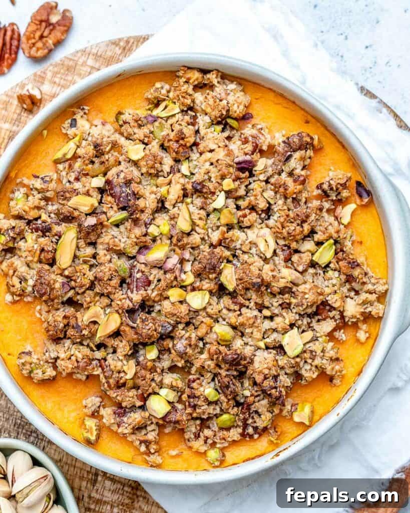 top view of sweet potato casserole in a white round dish with flour and sugary nuts topping