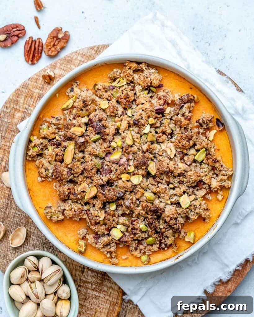 Top view of a white round casserole dish with sweet mashed sweet potato and a nut topping